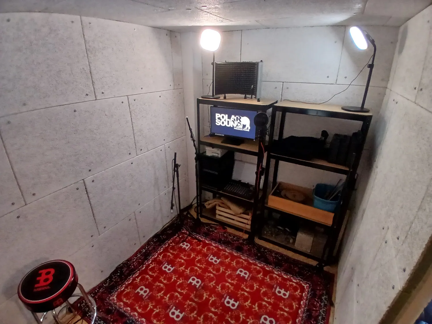 The Polarsound booth in Dornbirn: acoustic panelling, microphone stands, a shelf of foley material and the studio screen